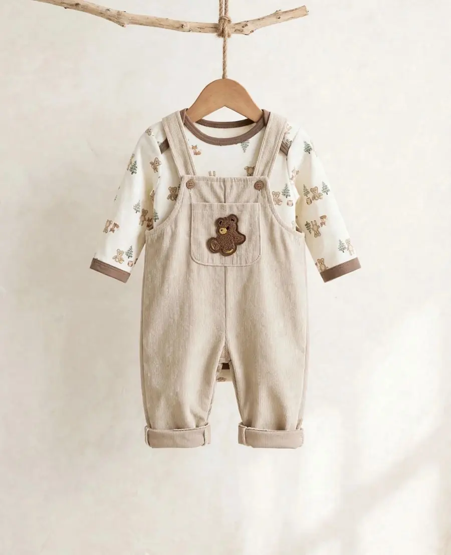 Jardinerito de pana beige con parche de osito, sobre body con estampado de bosque y ositos